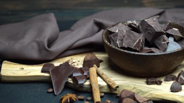 Donkere of melk biologische chocolade stukjes en truffel snoepjes in houten kom op donkere betonnen achtergrond — Stockvideo