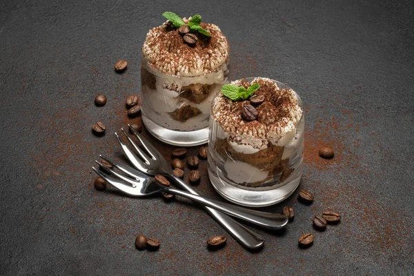 Two portions Classic tiramisu dessert in a glass on dark concrete background — Stock Photo, Image