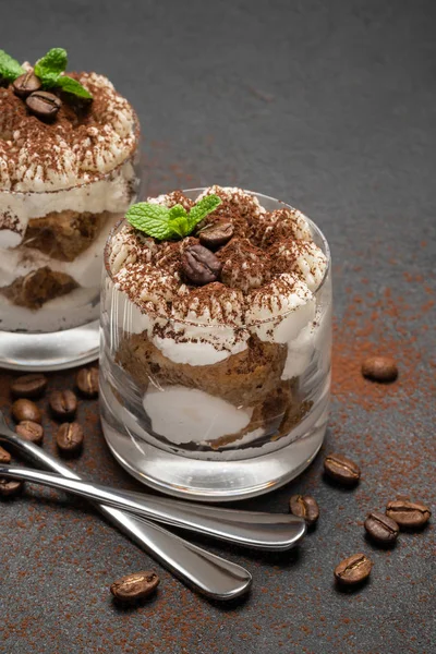 Two portions Classic tiramisu dessert in a glass on dark concrete background — Stock Photo, Image