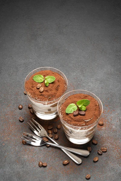 Two portions Classic tiramisu dessert in a glass on dark concrete background — Stock Photo, Image