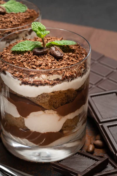 Dos porciones clásico postre tiramisú en una barra de vidrio y chocolate sobre fondo de hormigón oscuro —  Fotos de Stock