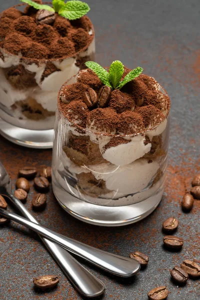 Zwei Portionen klassisches Tiramisu-Dessert im Glas auf dunklem Betongrund — Stockfoto