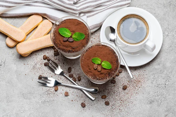 Классический десерт тирамису в стакане и чашка кофе на бетонном фоне — стоковое фото