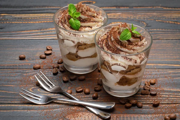 Due porzioni Classico dessert tiramisù in un bicchiere su sfondo di legno — Foto Stock