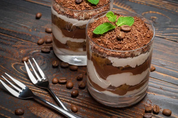 Due porzioni Classico dessert tiramisù in un bicchiere su sfondo di legno — Foto Stock