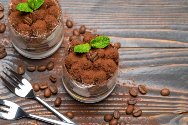 Ahşap arka plan üzerinde bir bardak iki porsiyon Klasik tiramisu tatlı — Stok fotoğraf