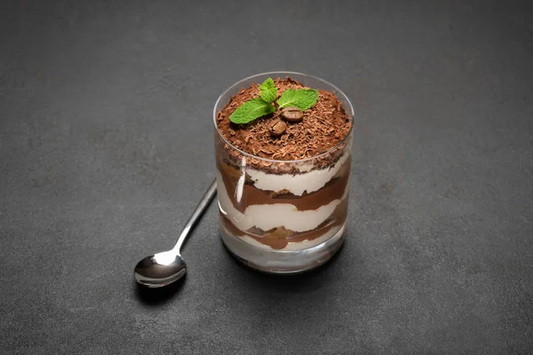Porzione di dessert tiramisù classico in un bicchiere su sfondo di cemento — Foto Stock