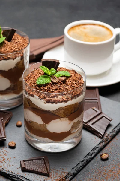 Klassisches Tiramisu-Dessert in Glas und Tasse Kaffee auf dunklem Betongrund — Stockfoto