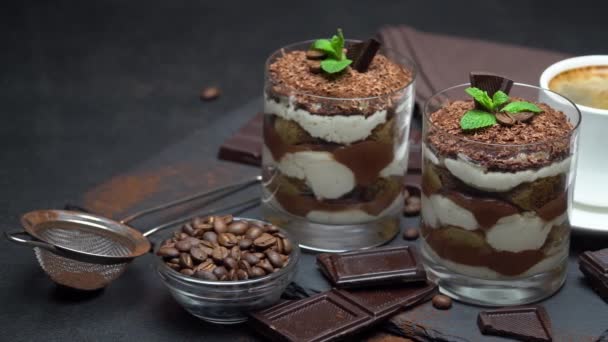 Classic tiramisu dessert in a glass and cup of coffee on dark concrete background — Stock Video