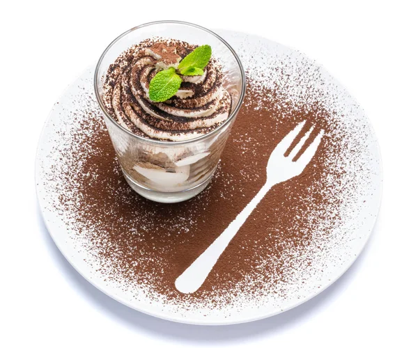 Классический десерт тирамису в стакане на тарелке с вилочным силуэтом, изолированным на белом с вырезкой — стоковое фото