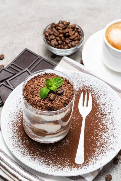 Klassiek Tiramisu dessert in een glas en kopje koffie op concrete achtergrond — Stockfoto