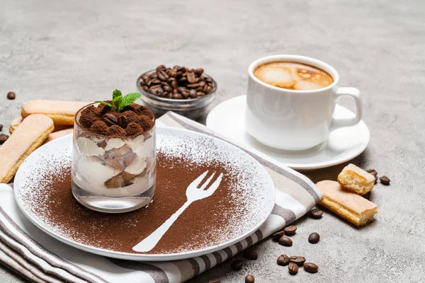 Классический десерт тирамису в стакане и чашка кофе на бетонном фоне — стоковое фото