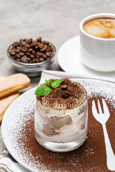 Sobremesa tiramisu clássico em um copo e xícara de café no fundo de concreto — Fotografia de Stock