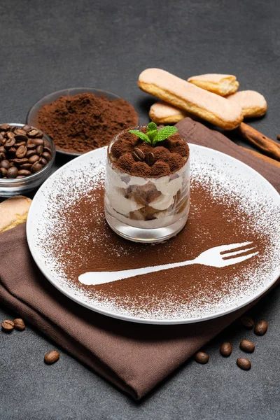 Classic tiramisu dessert in a glass and cup of coffee on dark concrete background — Stock Photo, Image