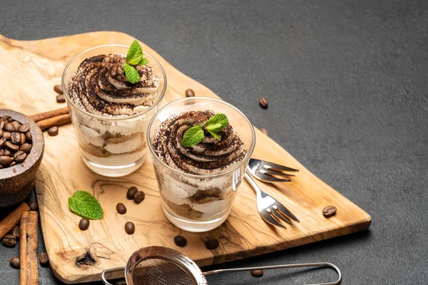 Класичний десерт тірамісу в келиху на темному бетонному фоні — стокове фото