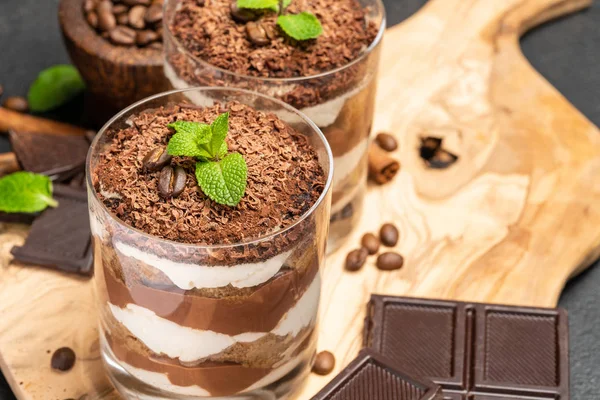 Sobremesa tiramisu clássico em um copo no fundo de concreto escuro — Fotografia de Stock