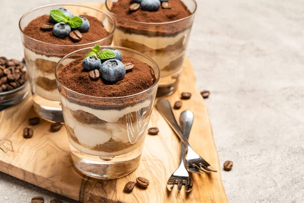 Postre tiramisú clásico en una copa con arándanos sobre fondo de hormigón —  Fotos de Stock