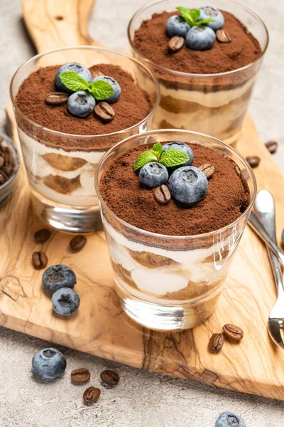 Klassisches Tiramisu-Dessert im Glas mit Blaubeeren auf Betongrund — Stockfoto