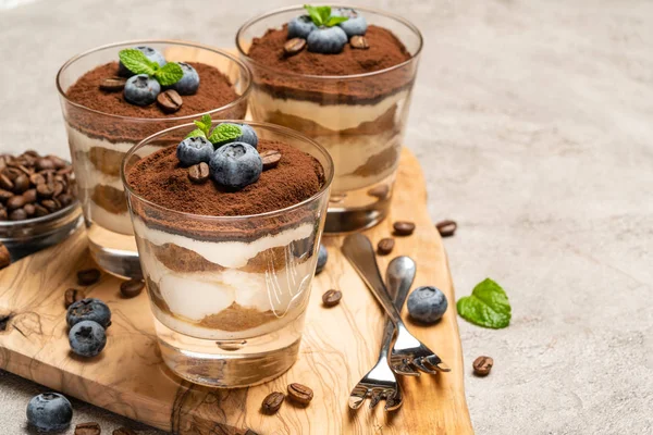 Klasszikus tiramisu desszert egy pohár áfonyával a beton háttér — Stock Fotó