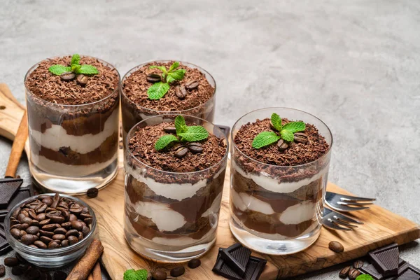 Classico dessert tiramisù in un bicchiere su sfondo di cemento scuro — Foto Stock