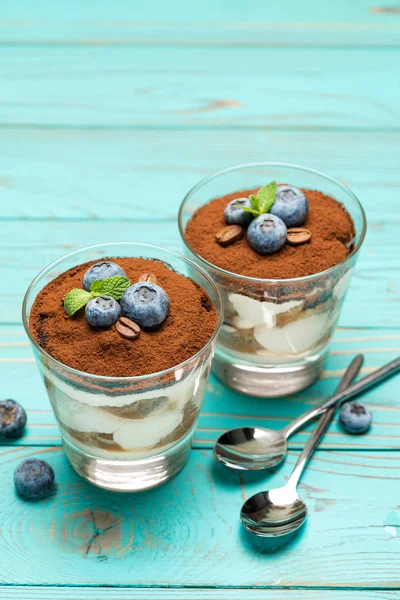 Klasszikus tiramisu desszert egy pohár áfonyával kék fa háttér — Stock Fotó