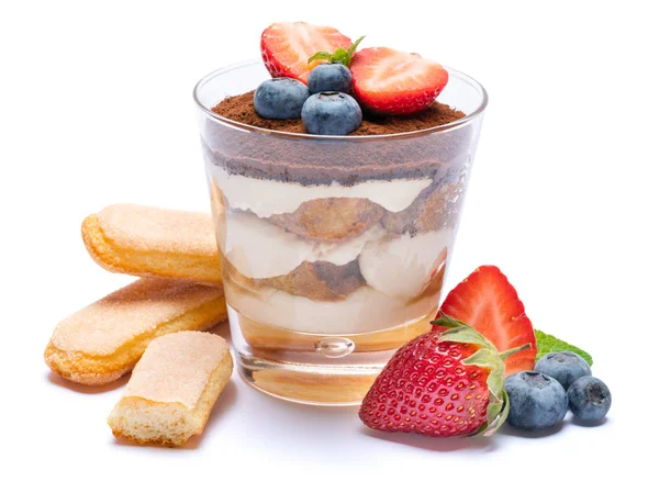 Класичний десерт тірамісу з чорницею, полуницею в склянці та печивом з сафарі ізольовані на білому з відсічним контуром — стокове фото