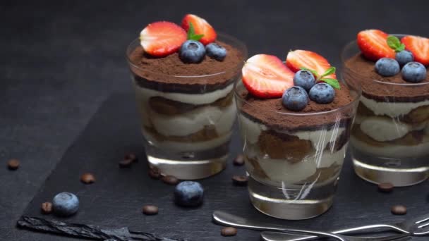 Postre clásico tiramisú con arándanos y fresas en un vaso sobre fondo de hormigón oscuro — Vídeos de Stock