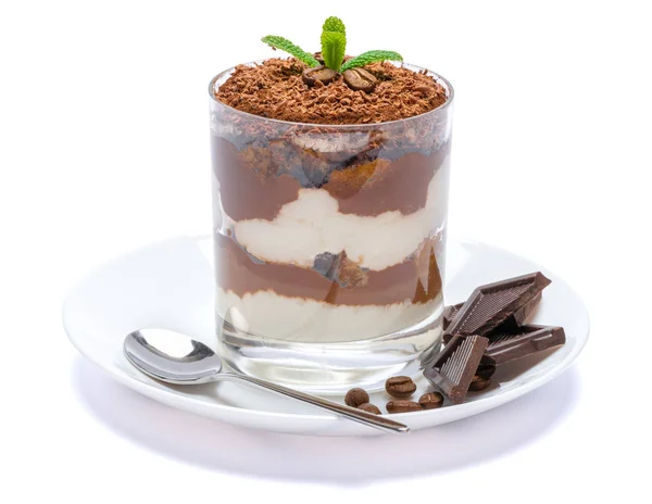 Klasyczny deser tiramisu w szklance na talerzu z łyżką wyizolowaną na białym z ścieżką przycinającą — Zdjęcie stockowe