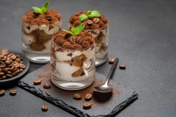 Classic tiramisu dessert in a glass on stone serving board on dark concrete background — Stock Photo, Image