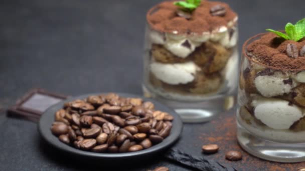 Postre tiramisú clásico en un vaso sobre tabla de servir de piedra sobre fondo de hormigón oscuro — Vídeo de stock