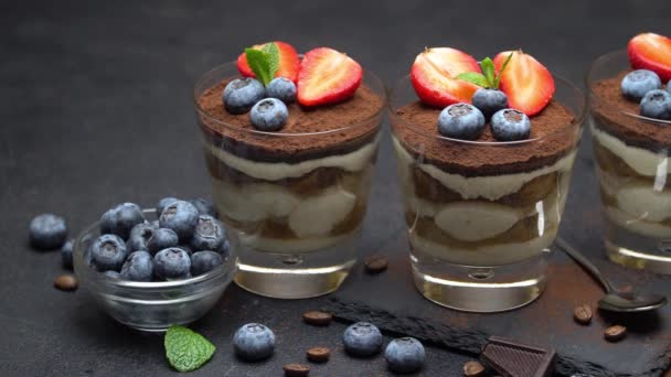 Postre tiramisú clásico con arándanos y fresas sobre tabla de servir de piedra sobre hormigón — Vídeos de Stock