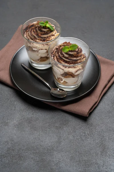 Sobremesa tiramisu clássico em um copo no fundo de concreto escuro — Fotografia de Stock