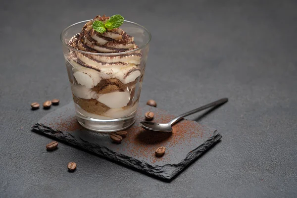 Klassisches Tiramisu-Dessert im Glas auf Steinplatte auf dunklem Betongrund — Stockfoto