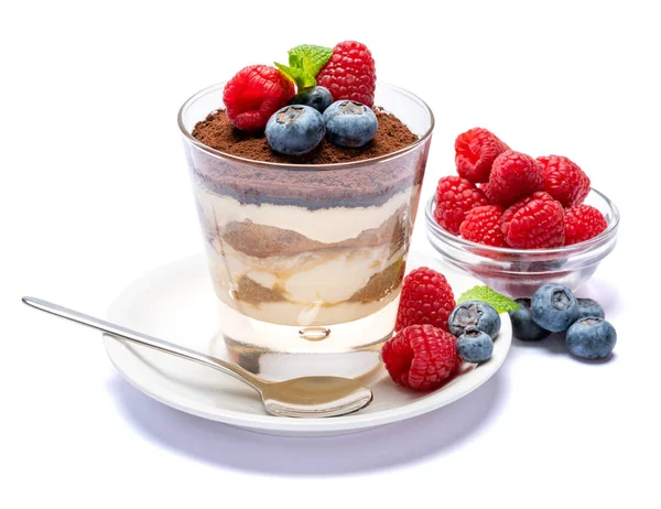 Классический десерт из тирамису с черникой и малиной в стакане, изолированном на белом фоне с вырезанной дорожкой — стоковое фото