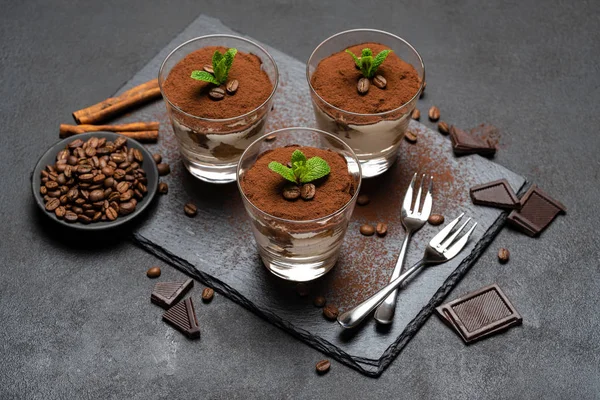 Klassisches Tiramisu-Dessert im Glas auf Steinplatte auf dunklem Betongrund — Stockfoto