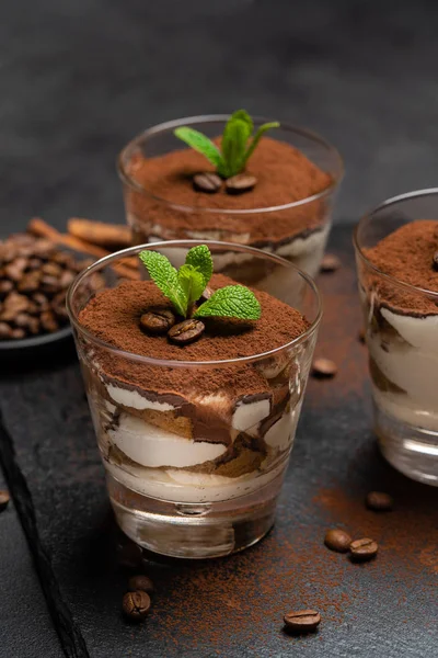 Postre tiramisú clásico en un vaso sobre tabla de servir de piedra sobre fondo de hormigón oscuro —  Fotos de Stock