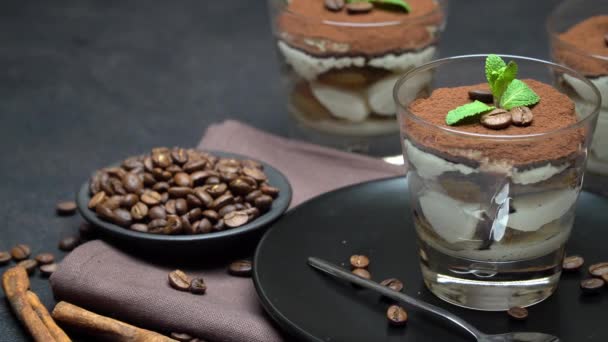 Классический десерт тирамису в стакане на темном бетонном фоне — стоковое видео