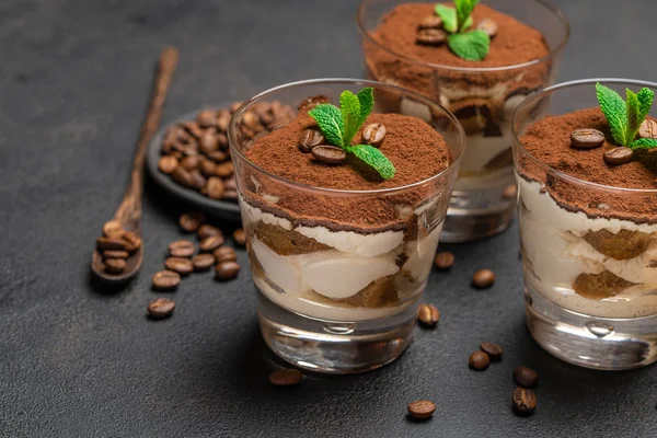 Classico dessert tiramisù in un bicchiere su sfondo di cemento scuro — Foto Stock