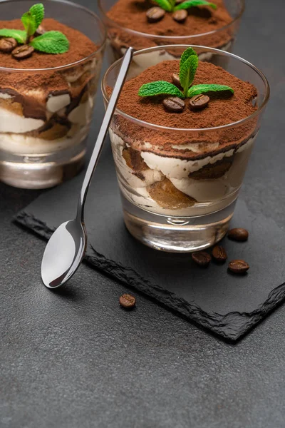 stock image Classic tiramisu dessert in a glass on stone serving board on dark concrete background