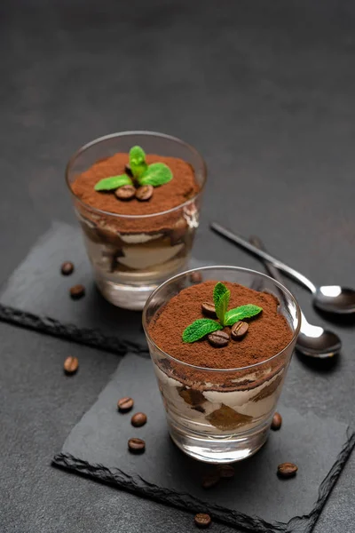 Classic tiramisu dessert in a glass on stone serving board on dark concrete background — Stock Photo, Image