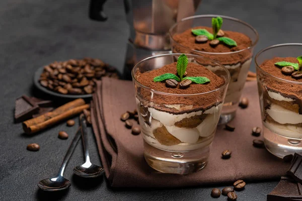 Postre tiramisú clásico en vaso y cafetera sobre fondo de hormigón oscuro —  Fotos de Stock