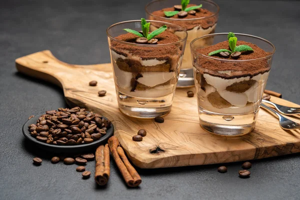 Classico dessert tiramisù con cioccolato in un bicchiere senza tagliere in legno su sfondo di cemento scuro — Foto Stock