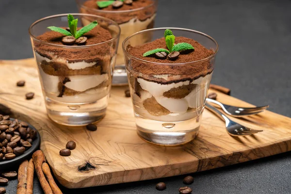 Sobremesa tiramisu clássico com chocolate em um copo sem corte de madeira boartd no fundo de concreto escuro — Fotografia de Stock