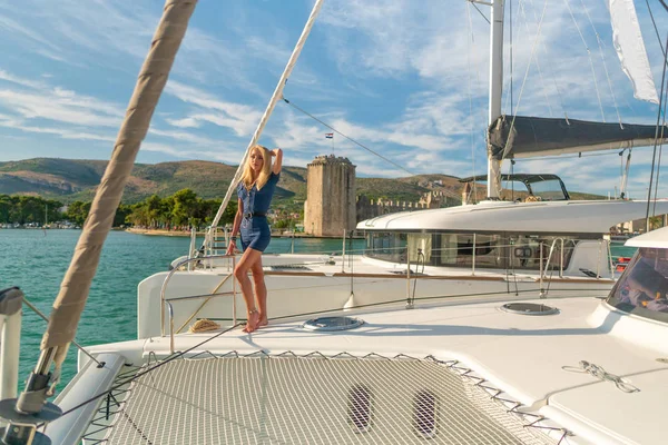 Mooie jonge vrouw in casual slijtage staande op een jacht Fore in Trogir Marina, Kroatië — Stockfoto
