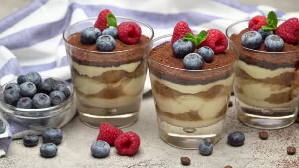 Klasický moučník tiramisu s borůvkami a maliny ve skleníku a ubrousku — Stock video