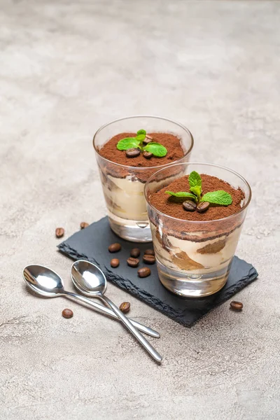 Classic tiramisu dessert in a glass on stone serving board on concrete background — Stock Photo, Image