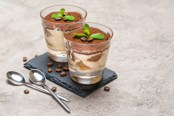 Classic tiramisu dessert in a glass on stone serving board on concrete background — Stock Photo, Image