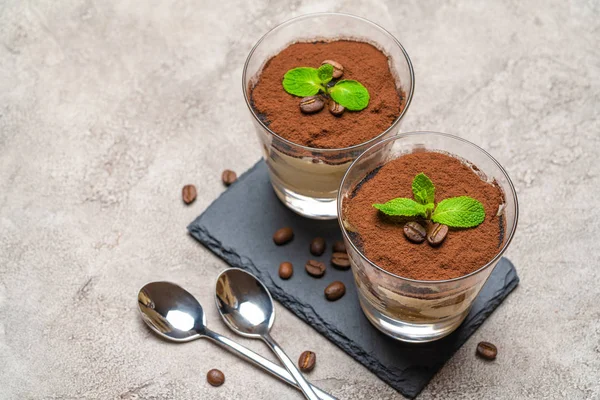 Beton arka plan üzerinde taş servis tahtası üzerinde bir bardak klasik tiramisu tatlı — Stok fotoğraf