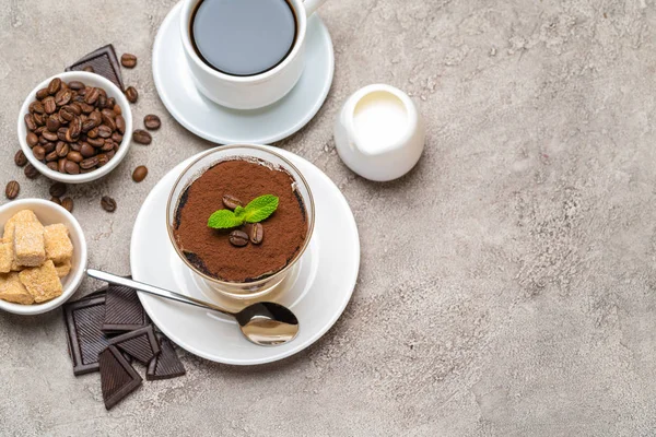 Klassiek Tiramisu-dessert in een glas, koffie, chocolade, room en suiker op een betonnen achtergrond — Stockfoto