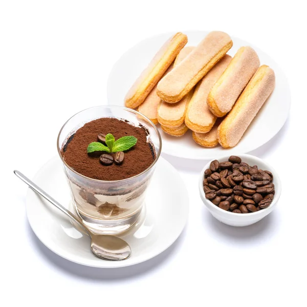 Postre tiramisú clásico en una taza de vidrio, galletas savoiardi y granos de café sobre fondo blanco con ruta de recorte — Foto de Stock